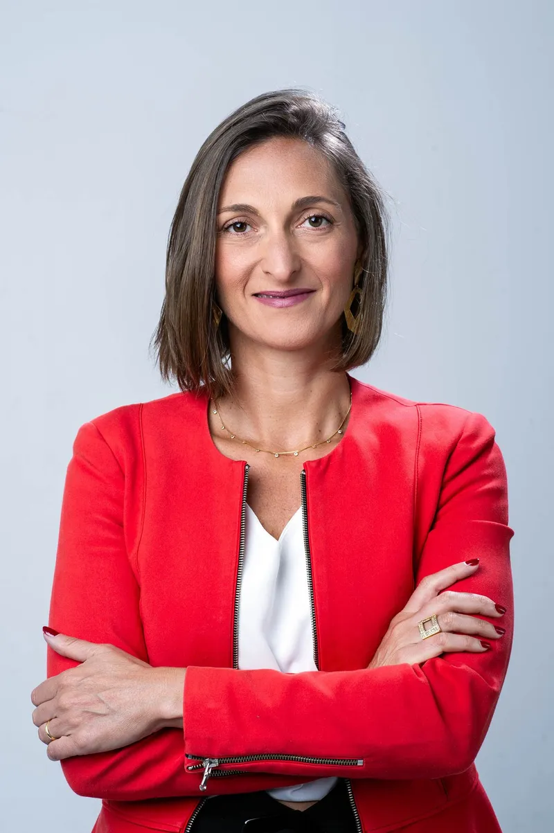 Andrea Castelli sorrindo, blazer vermelho